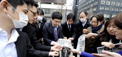 Un hombre reparte periódicos con las últimas noticias sobre la central nuclear de Fukushima, en una calle de Tokio.