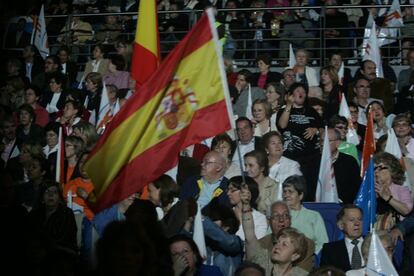 Asistentes al acto de cierre de campaña del PP madrileño con banderas españolas.