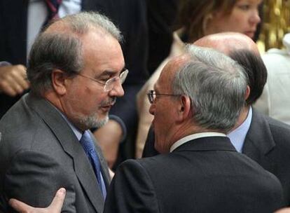 Pedro Solbes saluda al diputado del PP Manuel Pizarro ayer en el Congreso.