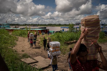 Traders unload merchandise at the port of Leticia, in the Amazonas (Colombia) on December 11, 2024.