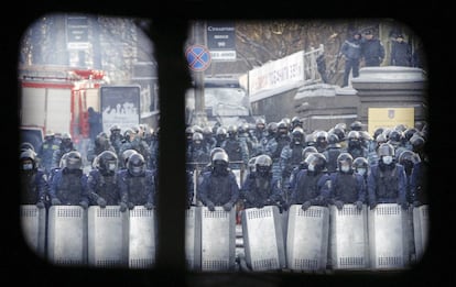 Tropas de la policía ucrania vistas a través de unas ventanillas en la zona de los disturbios con los manifestantes pro-europeos. 