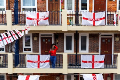 Una mujer sale fuera de su apartamento en Kirby Estate en Londres, que ha sido decorado con banderas de Inglaterra para la final de la Eurocopa. Esta es la primera vez que Inglaterra llega a una final de un gran torneo internacional de fútbol desde que ganase el Mundial en 1966.