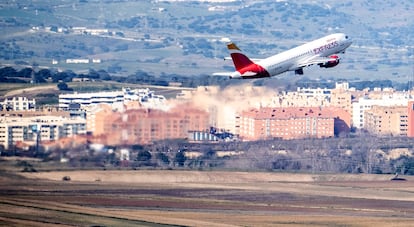 Vista panorámica del aeropuerto Adolfo Suárez de Madrid y un avión de Iberia Express despegando.