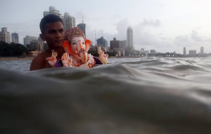 Un joven lleva una estatua del Dios Elefante para sumergirse con ella, en Ahmedabad (India), el 10 de septiembre de 2016.