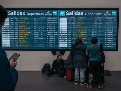 Pasajeros revisan el tablero de salidas en el Aeropuerto Internacional Benito Juárez (MEX) en la Ciudad de México, México, en 2022.