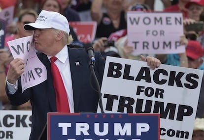 El candidato republicano a la presidencia de los Estados Unidos, Donald Trump, besa un cartel donde se puede leer 'Mujeres con Trump' durante un mitin en el aeropuerto de Lakeland, Florida, el 12 de octubre de 2016.