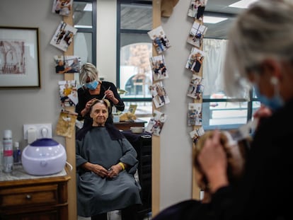 Una peluquera atiende a una paciente afectada por el alzhéimer en una residencia francesa.