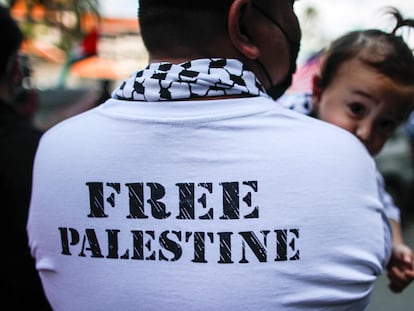 Un hombre vestido con la camiseta de 'Palestina libre' sostiene a su hija durante un mitin conmemorativo frente a la embajada de Estados Unidos en Kuala Lumpur, Malasia, el 29 de abril de 2022.