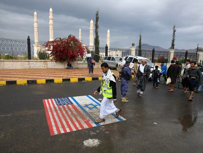 Un simpatizante huthi pisa dibujos de las banderas de EE UU e Israel en Saná para protestar contra la designación estadounidense de "terrorista" contra la milicia.