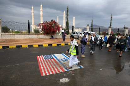 A Houthi supporter steps on drawings of the U.S. and Israeli flags in Sana'a after Washington declared the Houthis a terrorist group.