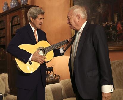 John Kerry toca la guitarra junto a José Manuel García Margallo, durante la reunión que mantuvieron en el Palacio de Viana.