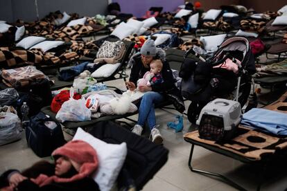 Una mujer con un bebé, en un centro comercial habilitado para los refugiados ucranianos en Mylny (Polonia), este domingo. 