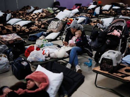 Una mujer con un bebé, en un centro comercial habilitado para los refugiados ucranianos en Mylny (Polonia), este domingo. 