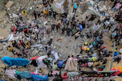 Equipos de emergencia ayudan a rescatar a víctimas entre los escombros de un edificio, destruido tras un ataque israelí, este lunes. 