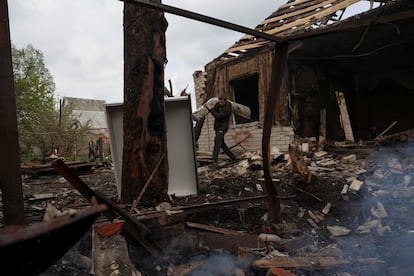 Un hombre carga con cosas rescatadas de una casa tras un ataque ruso en la localidad ucrania de Malotaranivka, el sábado.