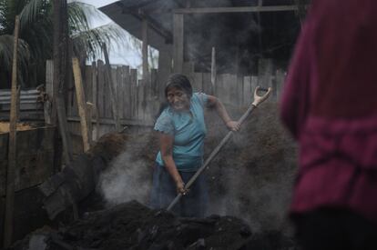 Rosario, la abuela de Manuel, entierra el carbón con serrín. Pese a tener más de 60 años, trabaja 12 horas al día. La familia Mellas es shipibo y cuentan que subsistían con lo que cosechaban y algunas ventas, pero bajó la demanda, tuvieron que ir a la ciudad y trabajar en las carboneras.