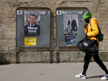 Un hombre camina frente a unos carteles electorales para las elecciones francesas, en París.