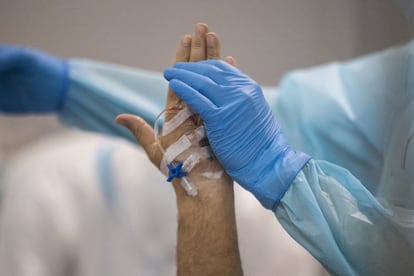 Un fisioterapeuta manipula los brazos de un paciente ingresado en el área de semicríticos del hospital. Durante el tratamiento contra la covid, estos pacientes reciben la visita periódica del fisioterapeuta para ayudar a la recuperación muscular.