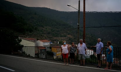 Habitantes de Robledo, el ltimo pueblo antes de llegar al Mirador de las Carrascas, al que no se poda acceder el pasado 13 de julio por el incendio. Los vecinos miran el fuego perplejos. Algunos hasta bromean. Harta estoy del mvil, todo el rato me estn llamando mis hijos para ver si estoy bien. ?No me dejen en paz!, deca entre risas una de las mujeres. Cuando empez a oler a humo, otra de las vecinas se asust y sac la mascarilla. Me ha dicho el mdico que me la ponga, que el humo es muy malo y yo tengo la salud muy delicada, deca preocupada.