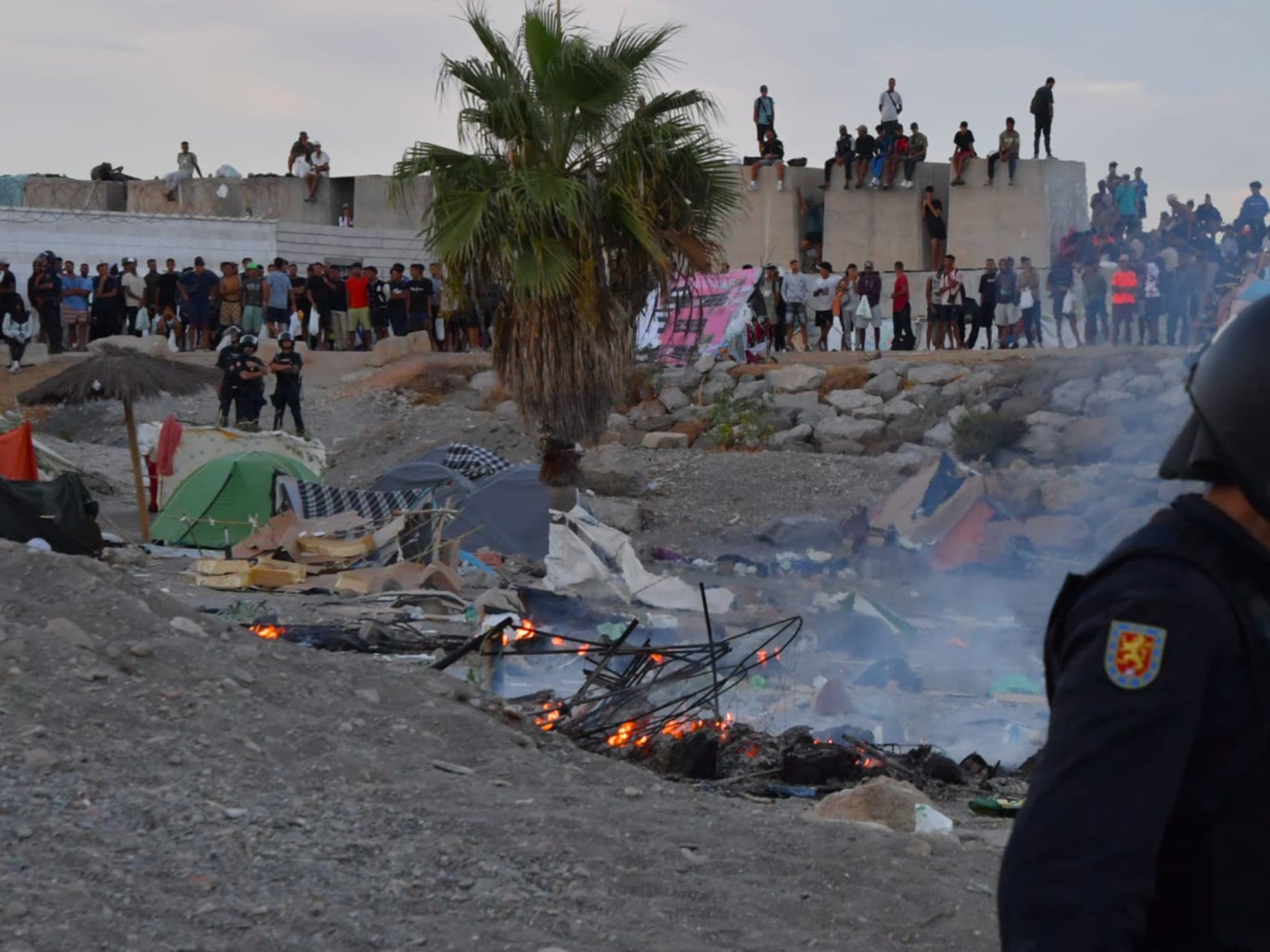 Actualidad de la entrada de inmigrantes a Ceuta - 27 de agosto de 2026 | Un grupo de ceutíes quema parte del campamento de los migrantes en una playa de Ceuta | España | EL PAÍS
