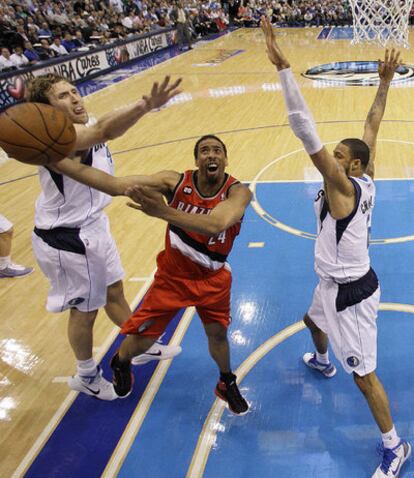 Andrew Miller, de Portland, intenta encestar ante la presión de Dirk Nowitzki y Tyson Chandler