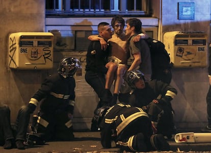 Los bomberos trasladan a un herido cerca de la sala de conciertos Bataclan.