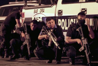 Policías federales y estatales, a resguardo durante el tiroteo en el penal de Ciudad Juárez.