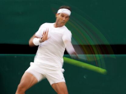 El tenista Rafael Nadal golpea la bola ante Federer en una acción del cuarto set.