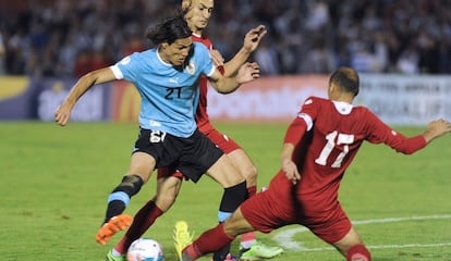 Hatem Aqel y Sharif Nassar pelean un bal&oacute;n con Edinson Cavani.