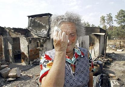 Una mujer llora ante su casa en Chamusca destruda por los incendios.