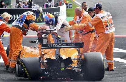 A equipe da McLaren ajuda Fernando Alonso a sair do carro.