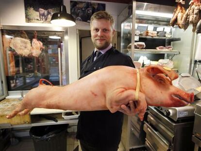 O açougueiro francês Bastien Nicolas posando com um porco.