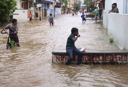 Un niño come un bocadillo en una calle inundada de Hyderabad (India).