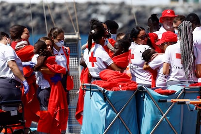 Red Cross volunteers helping children disembark at the port of Arguineguín (Gran Canaria).