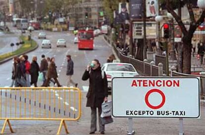 Una joven hace una foto entre unas vallas que impiden la circulación desde la plaza de Cibeles hacia la Gran Vía y la Puerta del Sol.