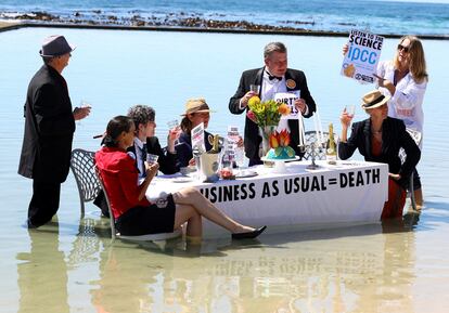 Varios activistas de Extinction Rebellion llevan a cabo una protesta en forma de obra de teatro en una playa de Ciudad del Cabo, Sudáfrica.