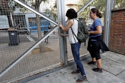 Dues dones obren la tanca del col·legi Torrent D'en Melis de Barcelona, activistes pretenen ocupar els col·legis que obriran el dia 1-O per evitar que s'impedeixi votar en el referèndum.
