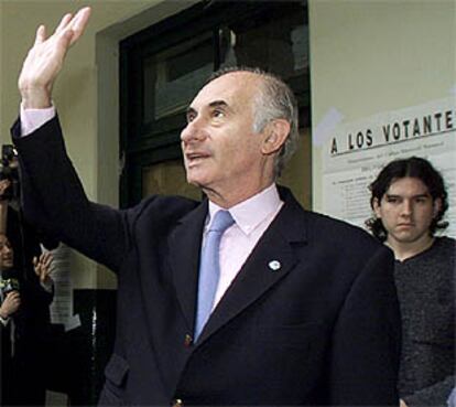 El presidente De la Rúa saluda tras depositar su voto, en Buenos Aires.