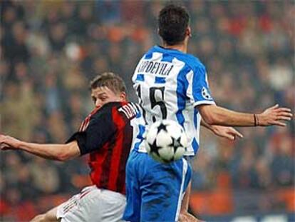 Capdevila y Tomasson saltan por el balón.