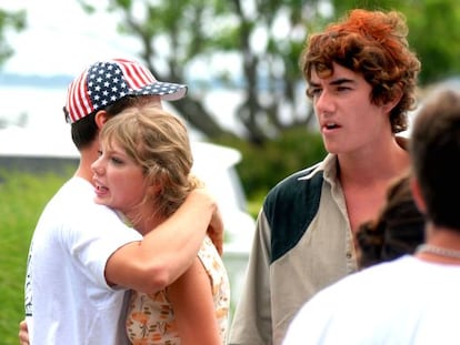 Taylor Swift abraza a un joven bajo la atenta mirada de su novio Conor Kennedy.