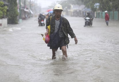 Un hombre camina por las calles inundadas de Camarines, en la Provincia del Este, Filipinas. Los habitantes de la ciudad comienzan a regresar poco a poco a sus hogares después de que el gobierno dijera que lo peor del Tifón ya había pasado.