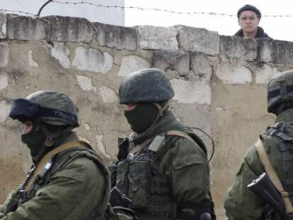 Un hombre ucranio observa a unos uniformados en la base militar de Perevalnoye (Crimea), este jueves.