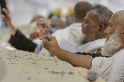 Los peregrinos musulmanes sostienen piedras en sus manos antes de arrojarlas al enorme pilar de piedra, representando así la lapidación del diablo, durante la peregrinación anual del Haj, en Mina, en las afueras de La Meca.