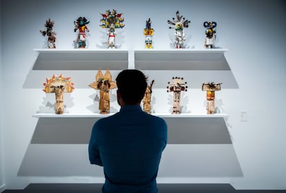 Un visitante observa las kachinas del espacio de Luis Feito.