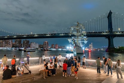 Un grupo de personas observan el buque escuela Cuauhtémoc junto al puente de Brooklyn, en Nueva York (EE.UU.).
