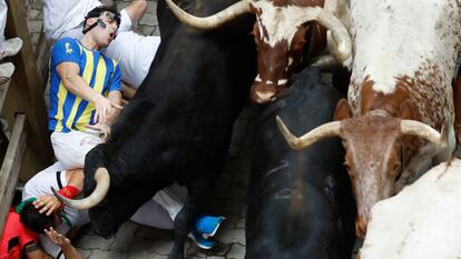 Varios mozos caen mientras son perseguidos por toros de Victoriano del Río, en el tercer encierro de los Sanfermines.