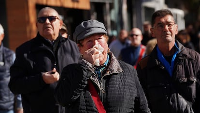 Vecinos observan a los bomberos trabajar en el edificio incendiado de Valencia.