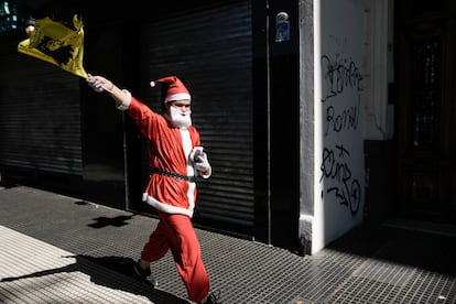 Un seguidor del nuevo presidente libertario de Argentina disfrazado de Santa Claus camina hacia el Congreso para reunirse con los demás simpatizantes de Milei.