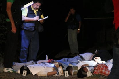 The police examine the bodies found in Morelia, which showed signs of torture and were left with notes signed with the initials T. A.