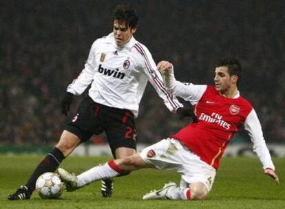 Kaká protege el balón ante Cesc en un partido frente al Arsenal.